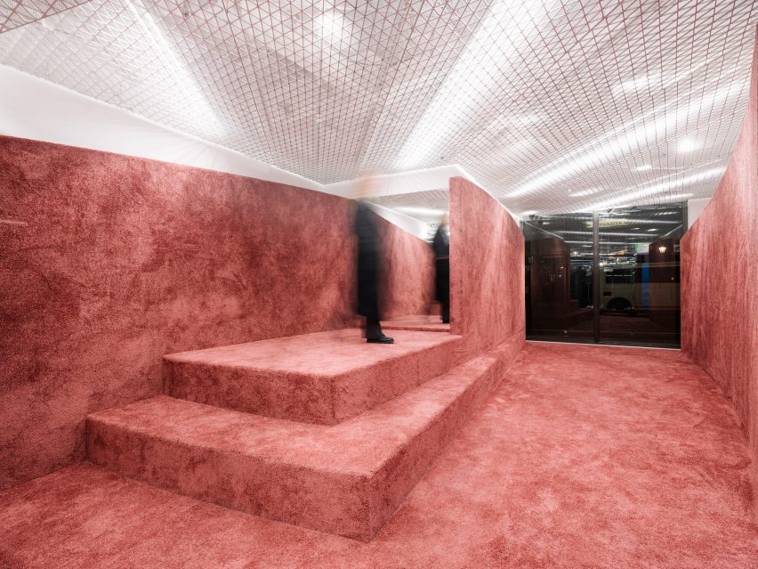 Shop interior with rammed-earth floor, steps and partition wall