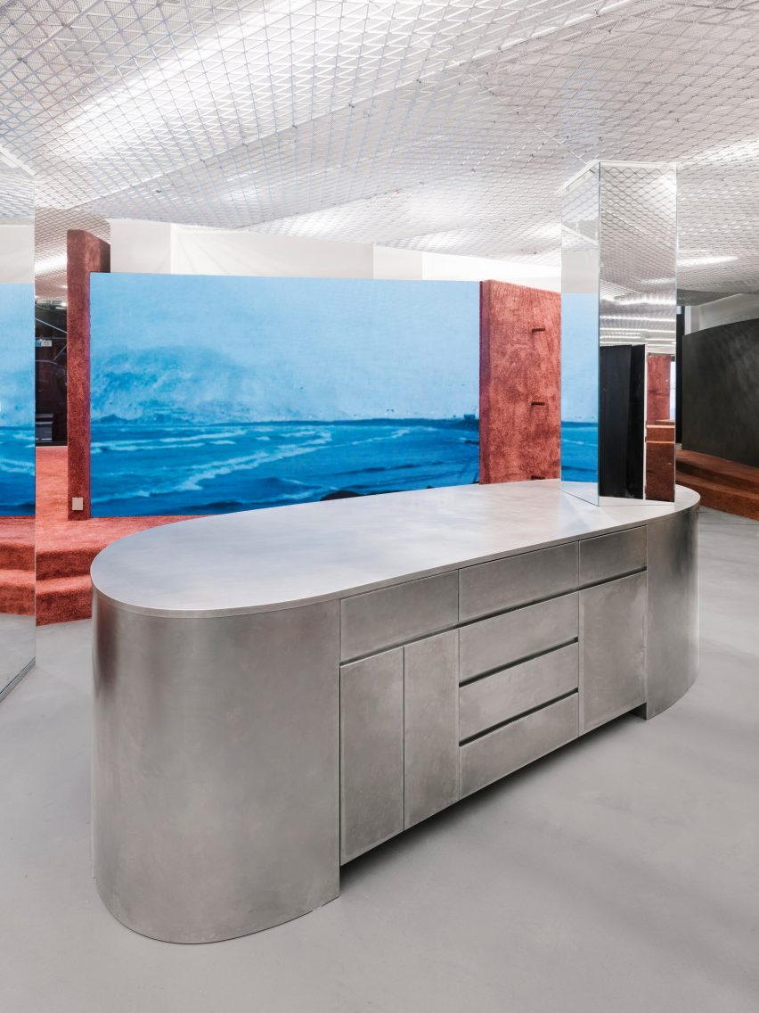 Shop interior with silver storage island and terracotta carpeted steps
