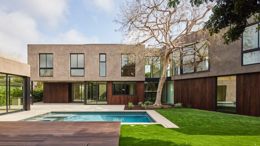Two storey concrete and timber house with a grassy back garden and swimming pool
