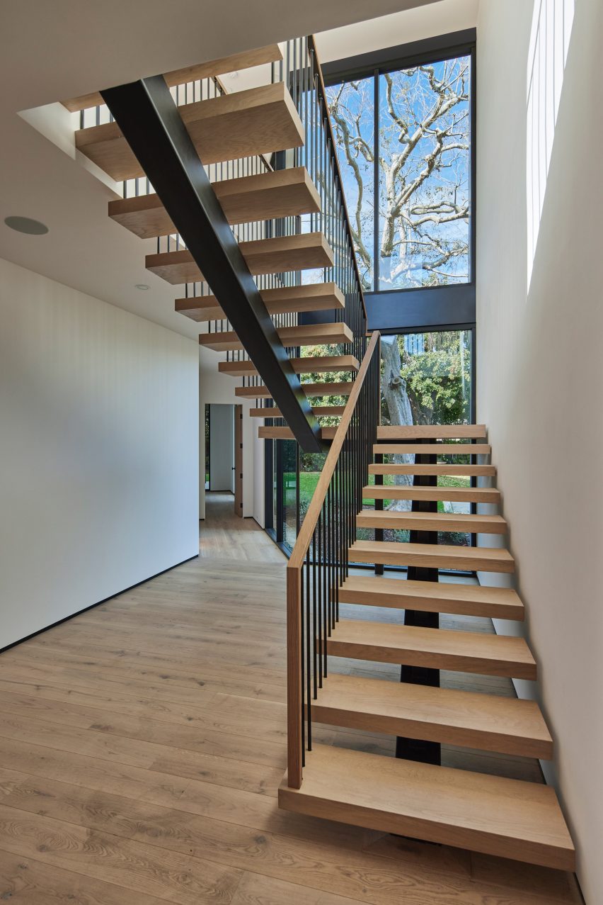 An oak staircase with a large window overlooking an elm tree