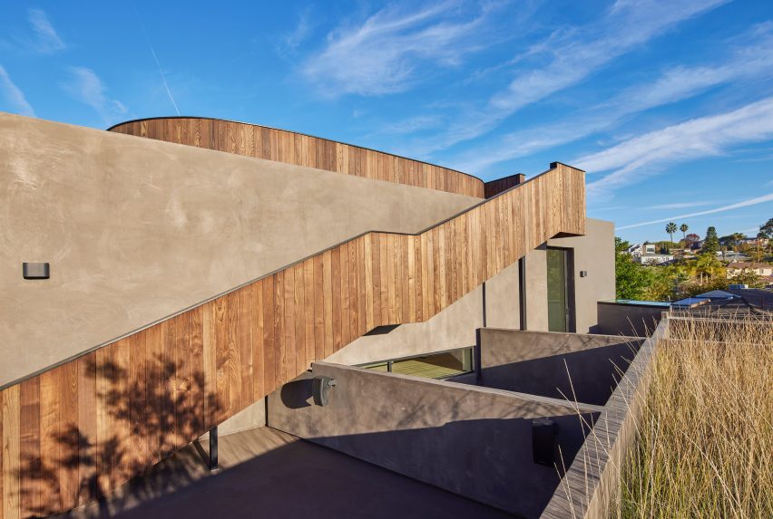 Timber-clad external staircase attached to a stucco home