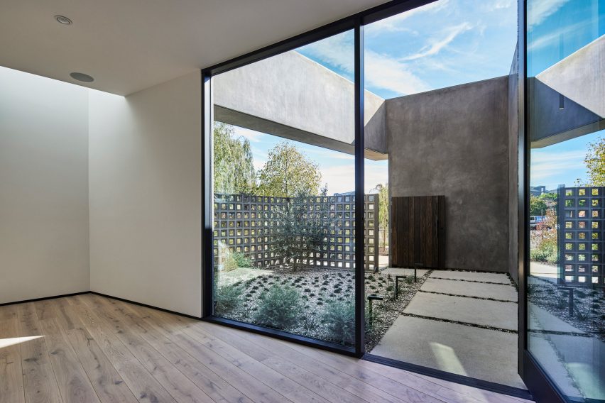 A room with large sliding glass doors leading to a planted roof terrace