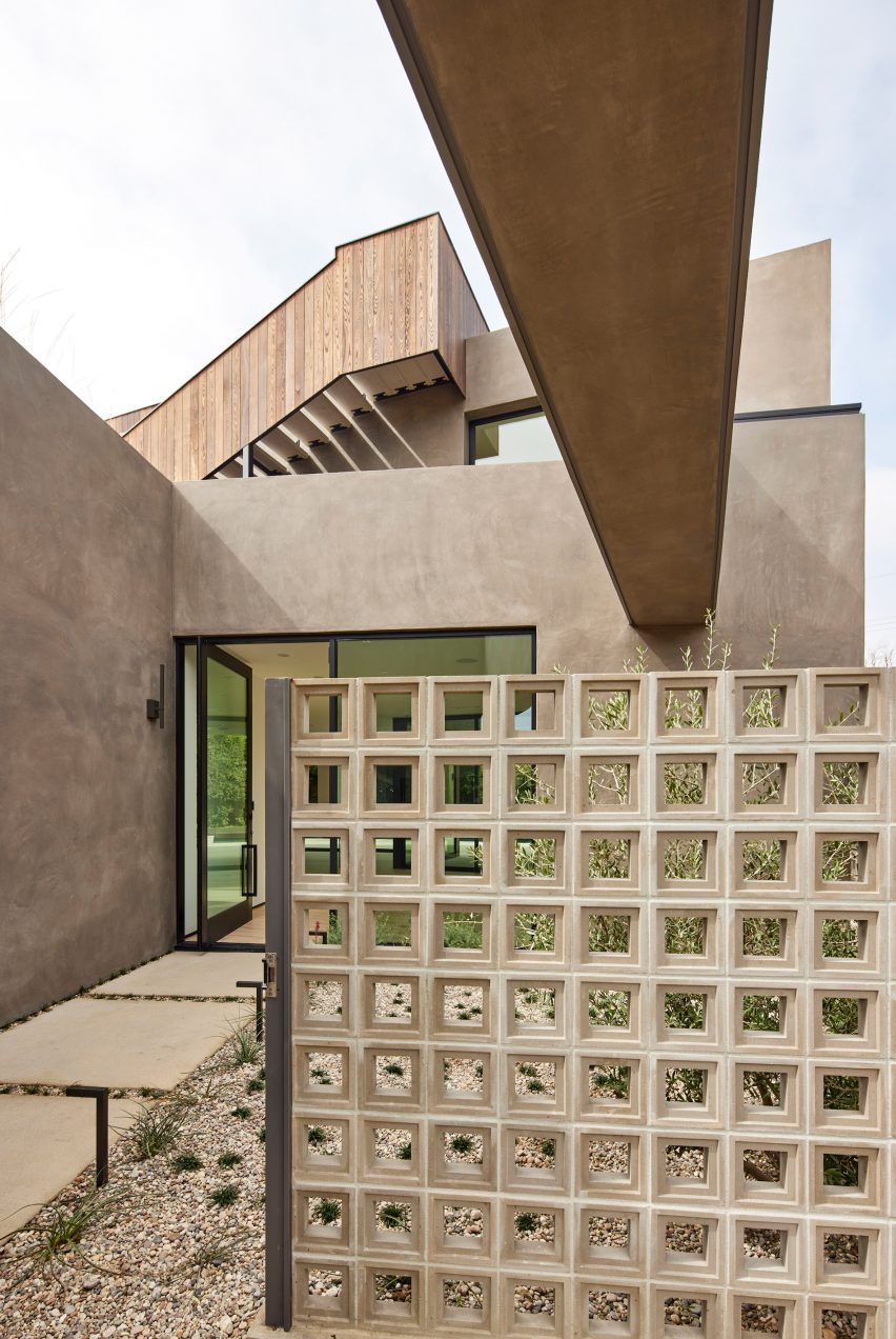 Roof terrace with a perforated partition wall at a home with stucco walls
