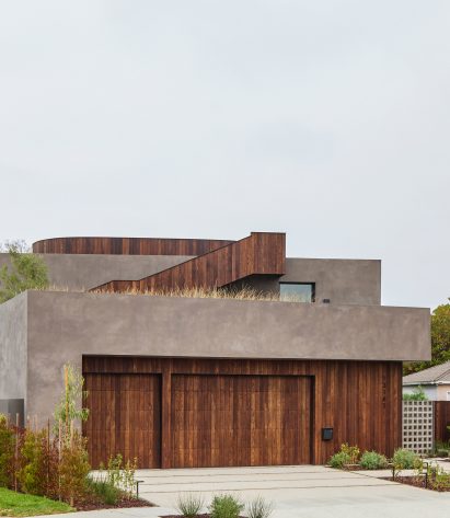 Concrete rectangular house with timber panelling on the ground floor and external staircase