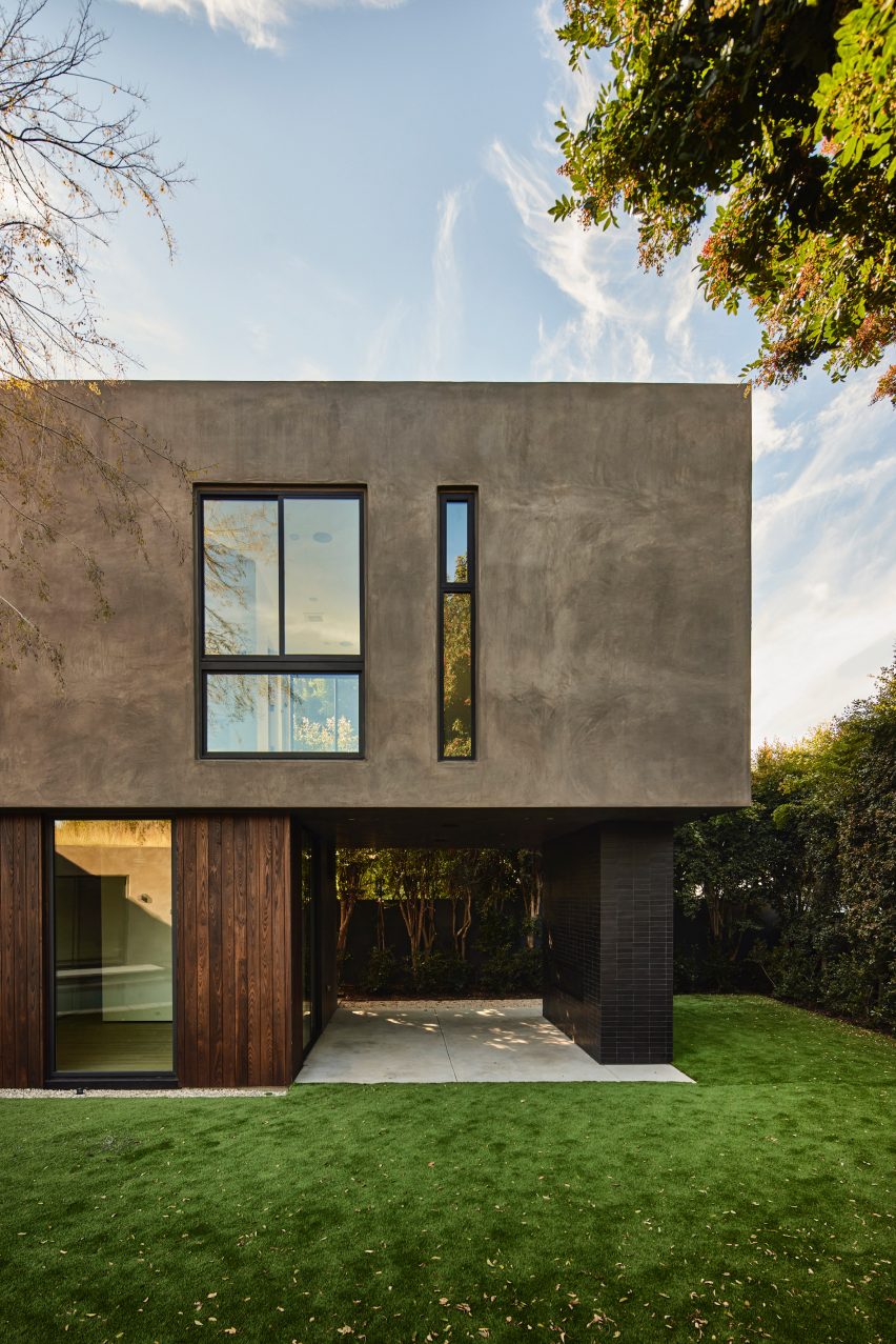 Stucco and ash-clad two-storey home on a grassy lawn
