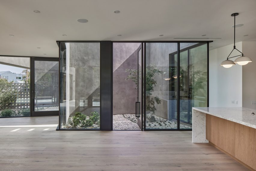 A white room with floor-to-ceiling glazing overlooking a courtyard
