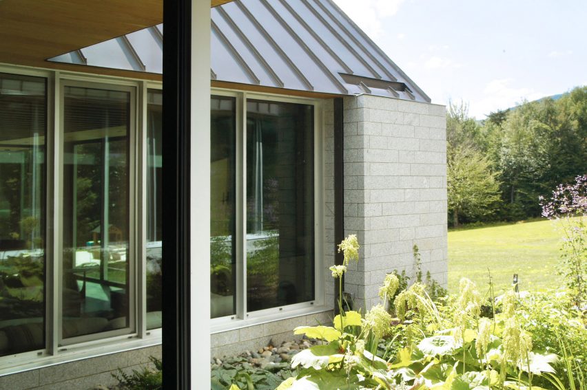 One-storey brick building with a pitched metal rood and planted garden in front