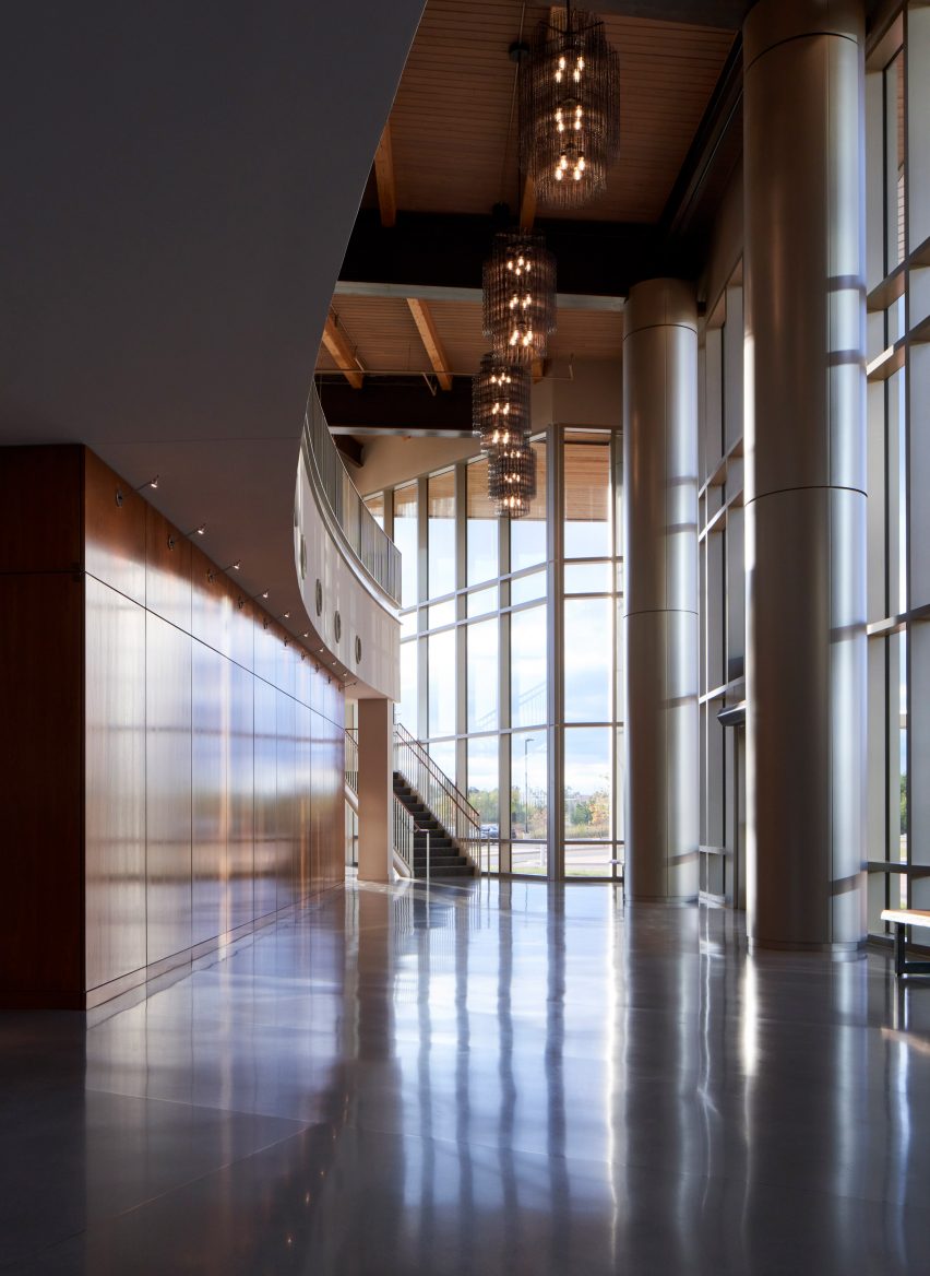 Interior museum space with concrete floors, circular steel columns and glazed facade