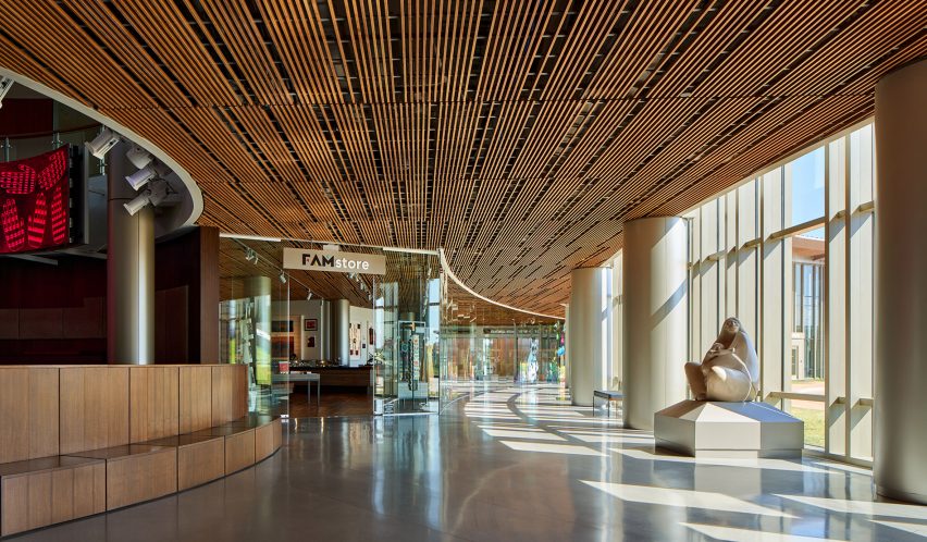 Interior museum gallery space with concrete floor and timber ceiling and glazed wall
