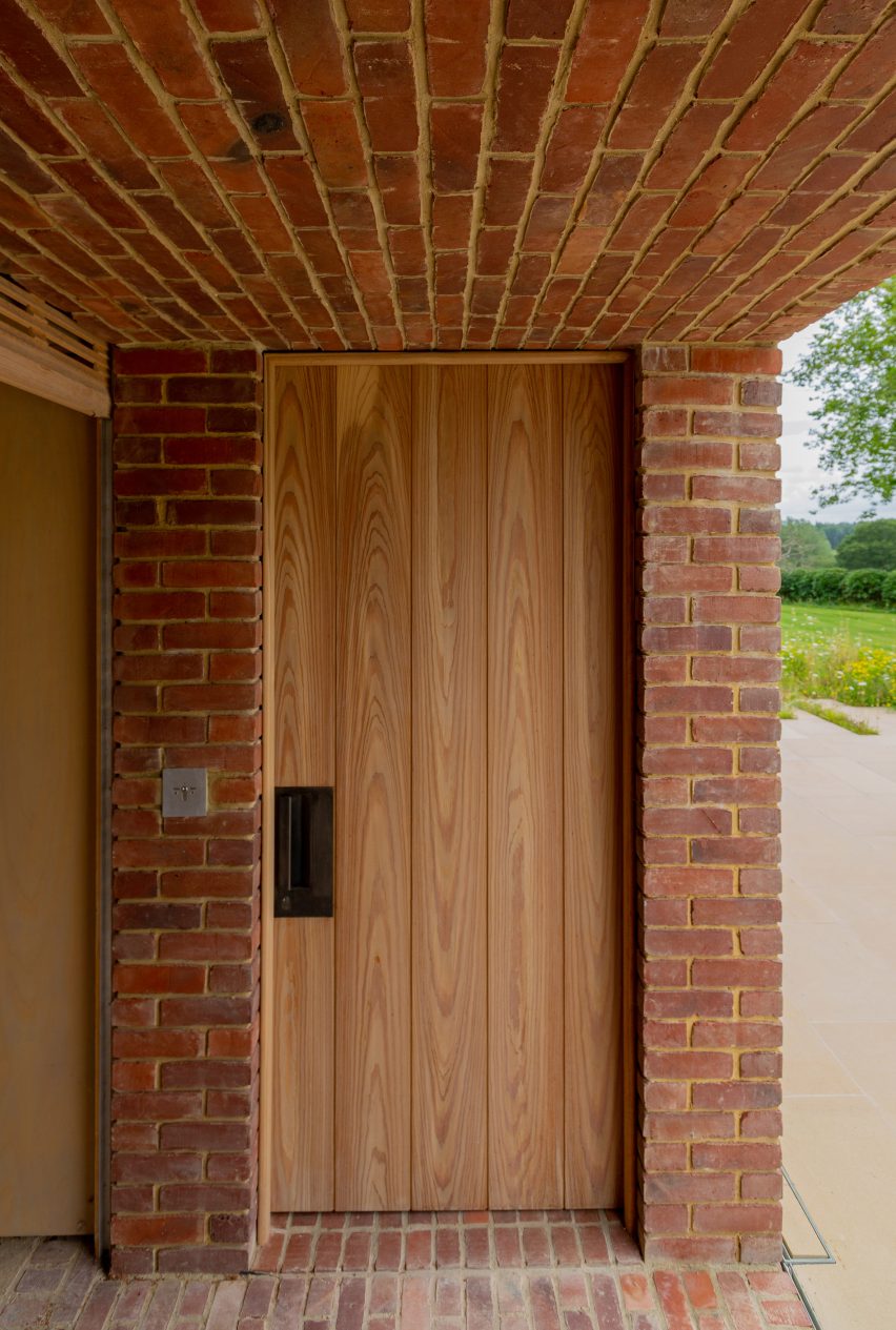 A structure with brick walls, floor and ceiling and a wooden door