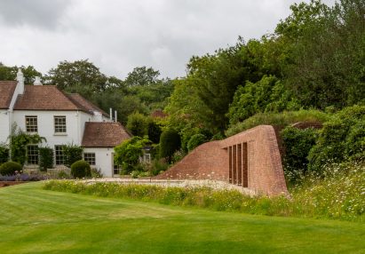 Brick pool house by Knox Bhavan buried under a grass mound in the garden of a Georgian home