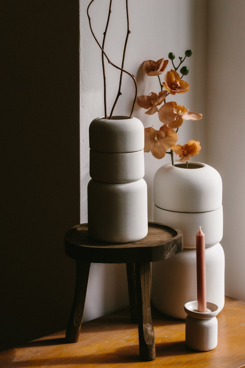 Three stoneware urns with flowers and candle