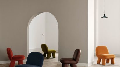 Orange rounded chair on mezzanine below wavy ceiling