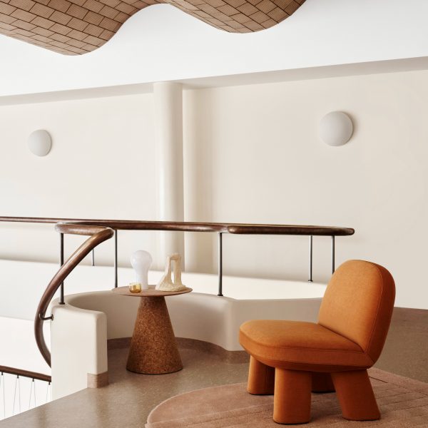 Orange rounded chair on mezzanine below wavy ceiling