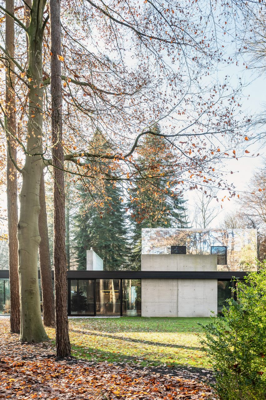 Two-storey home in a forest with a glazed ground floor and mirror-clad upper floor