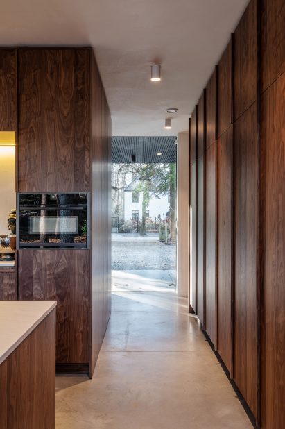 Narrow walkway ending in a floor-to-ceiling window with dark wood wall panelling