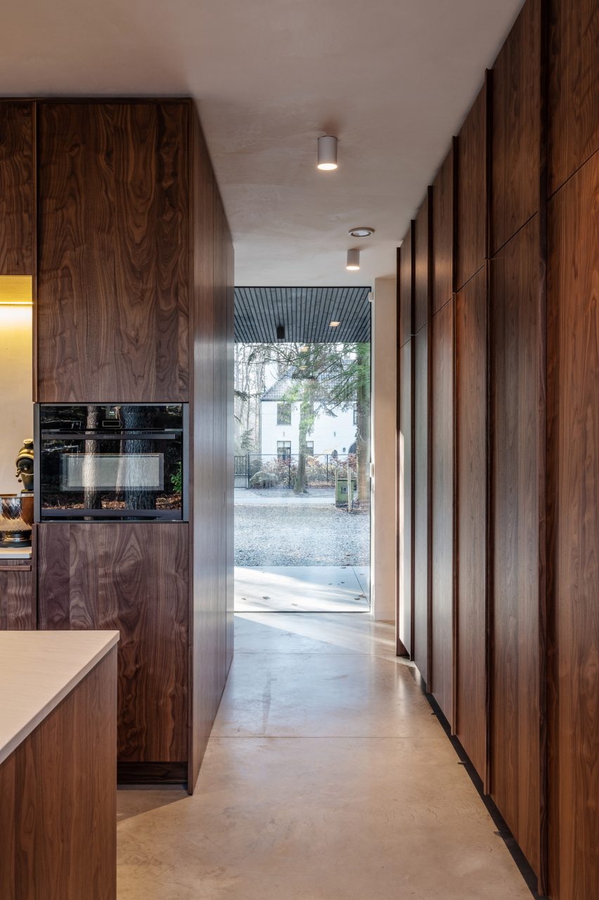Narrow walkway ending in a floor-to-ceiling window with dark wood wall panelling