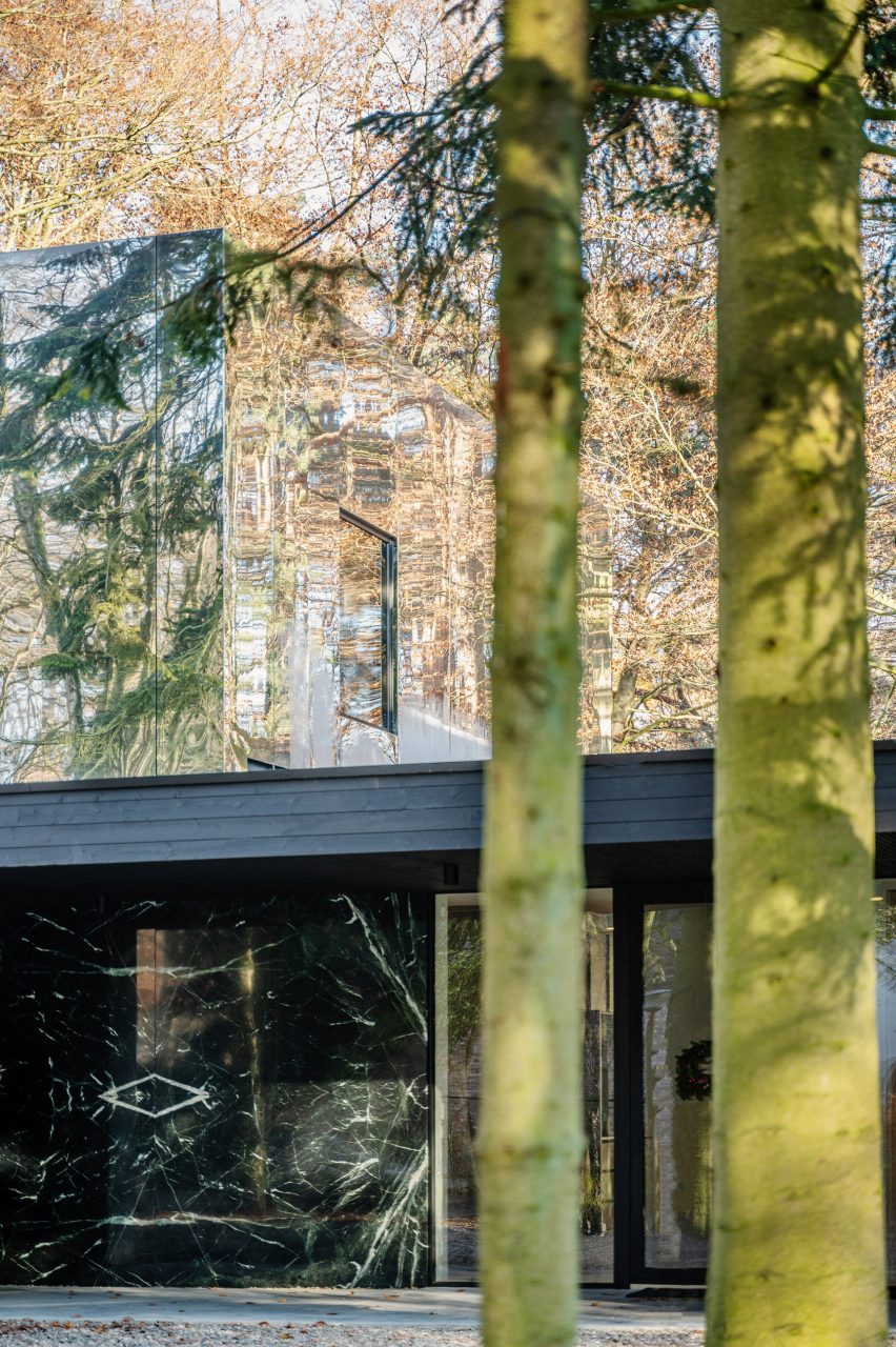 Two-storey home in a forest with a mirror-clad upper level