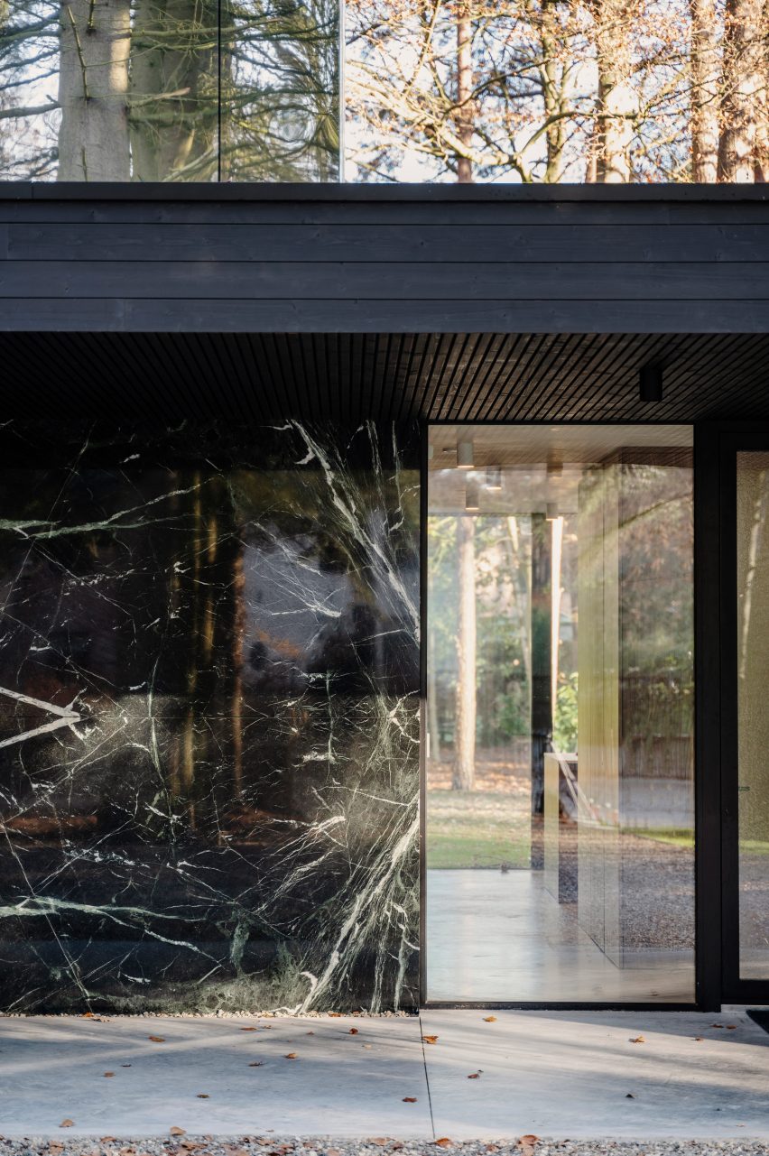 Exterior of a home with a marble wall and floor-to-ceiling window