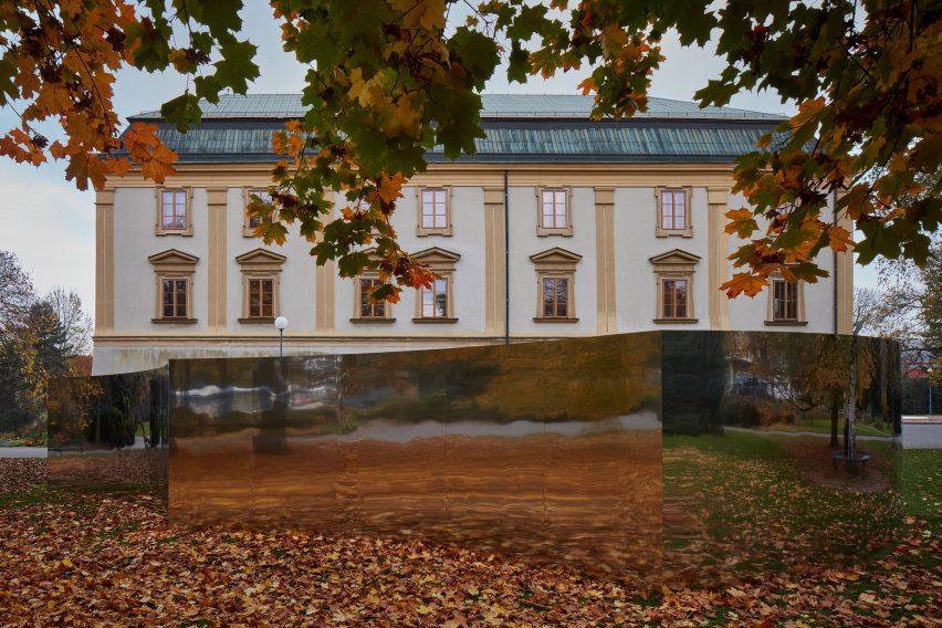 Mirrored curved structure in front of castle