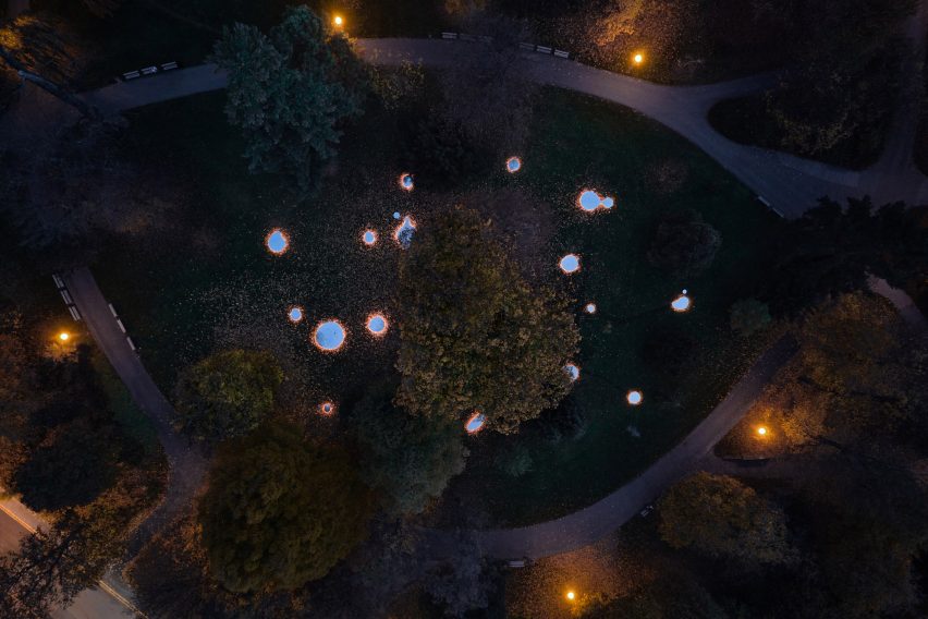 Aerial photograph of mirrors glowing on ground around trees at night