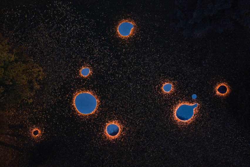 Aerial photograph of mirrors glowing on ground around trees at night
