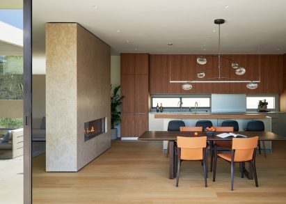 Limestone boxy fireplace within living space of Californian house