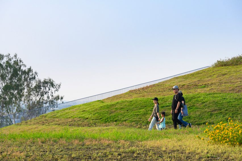 People walking on the undulating green roof of the Tainan food market by MVRDV