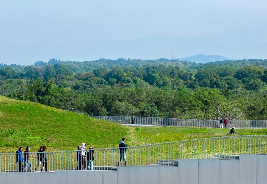 People walking on the undulating green roof of the Tainan food market by MVRDV