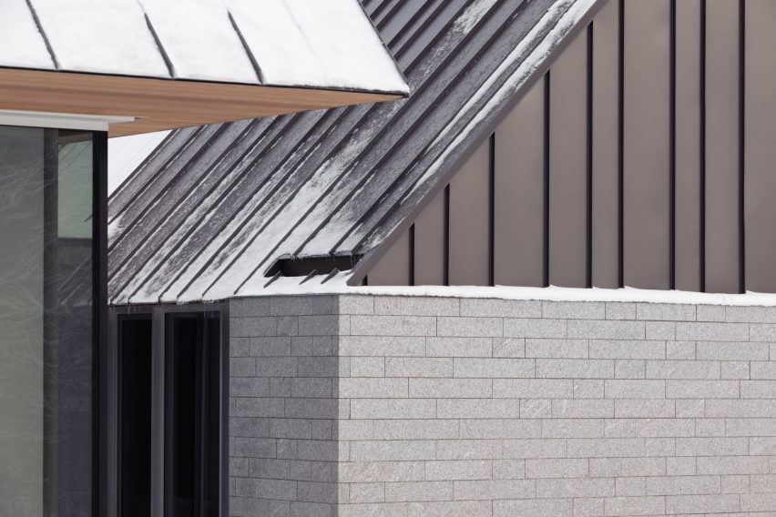 Close up of the granite walls and metal roofs of the Three Summits house by Nós