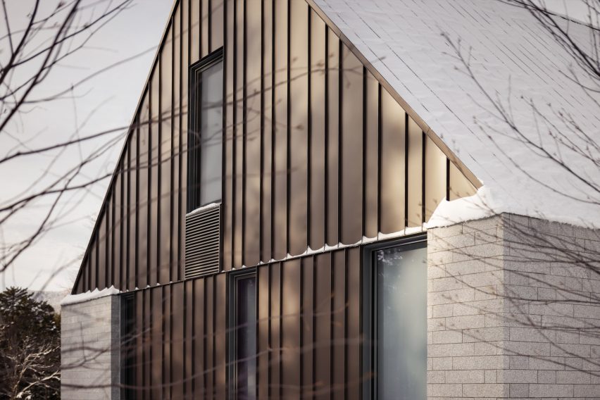 Close up of the granite walls and metal roofs of the Three Summits house by Nós