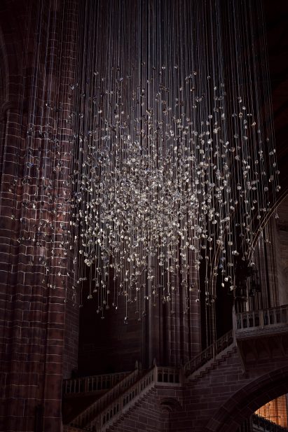 Spherical installation made up of suspended piece of coal illuminated inside a cathedral