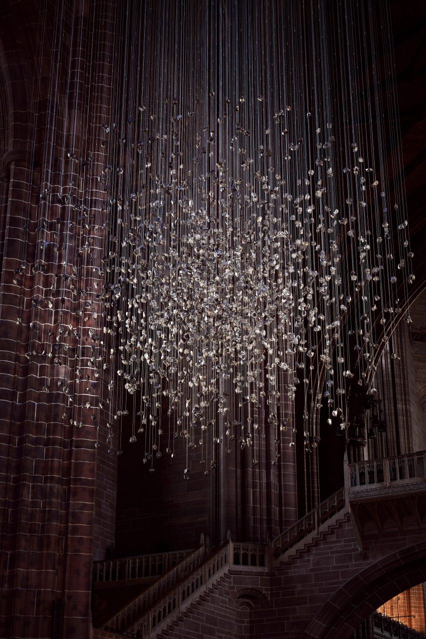 Spherical installation made up of suspended piece of coal illuminated inside a cathedral