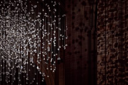 Spherical installation made up of suspended piece of coal illuminated inside a cathedral