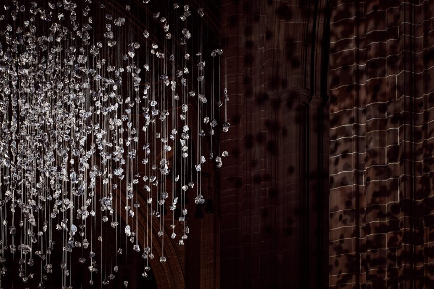 Spherical installation made up of suspended piece of coal illuminated inside a cathedral
