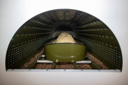 Body in cradle being pushed into human composting vessel at Recompose in Seattle