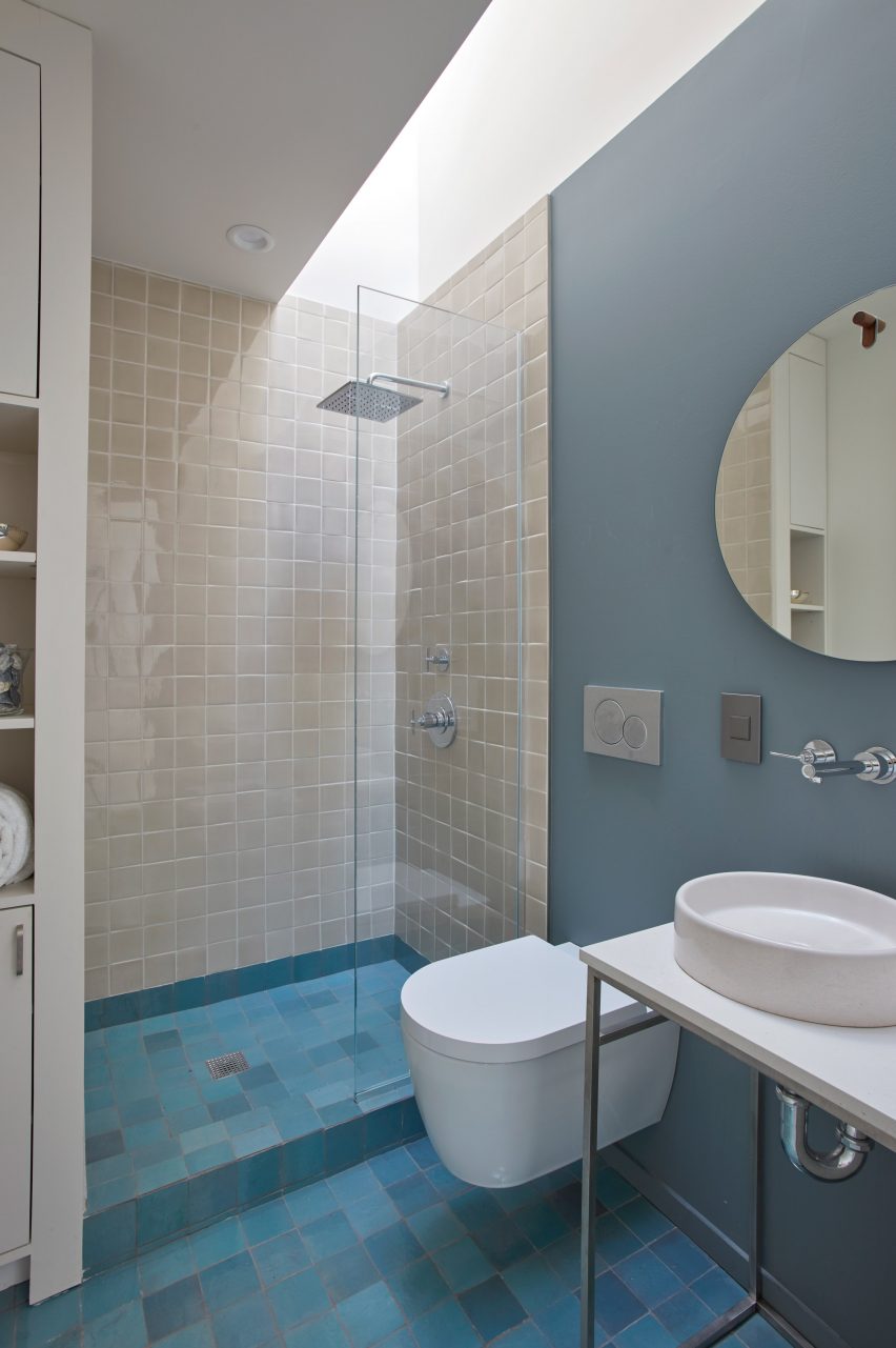 Bathroom with blue floor tiles, white sanitary ware and cream shower tiles
