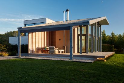 Exterior of a large porch of a house with cedar-clad walls and pitched roof
