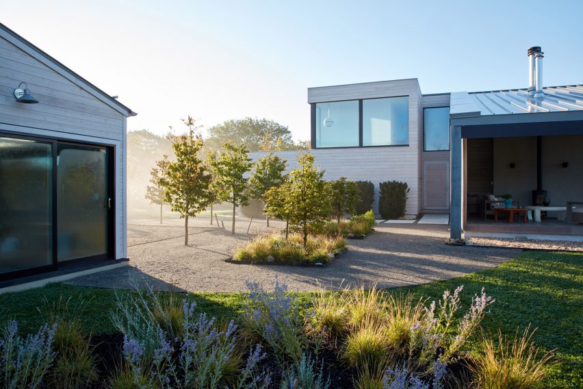Gravel courtyard with trees and two residential buildings on either side