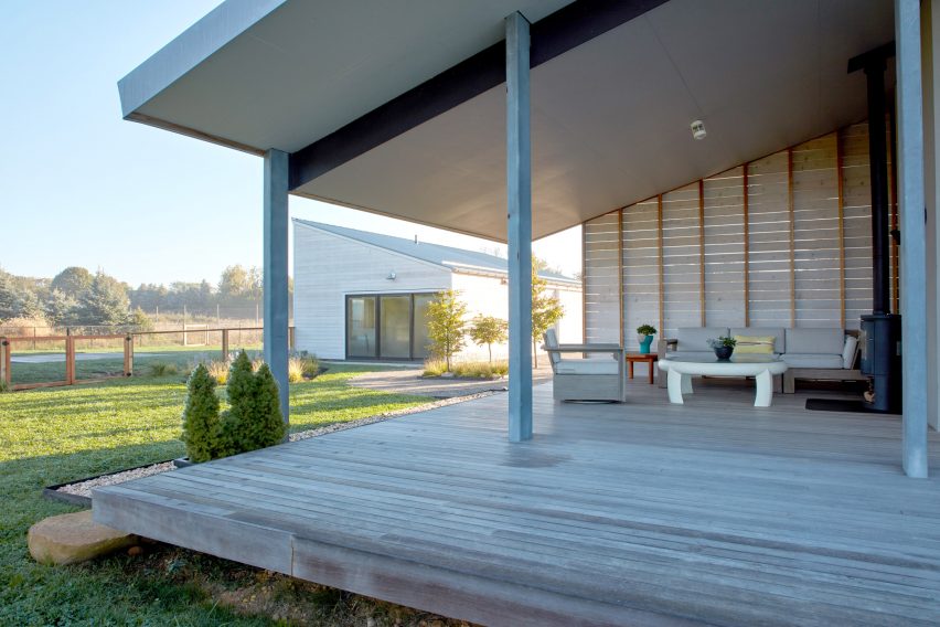 Timber porch with a sloping roof and sofa and lounge seating around a table