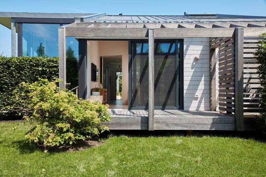 One-storey timber building with a porch on a grassy garden