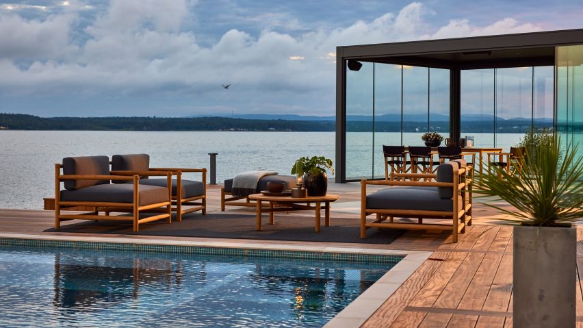 Grey upholstered sofas on a terrace by a pool with a sea view