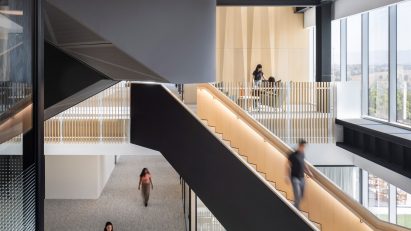 Black staircases dogleg up a light-filled void