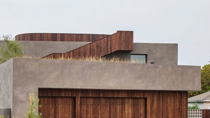 Concrete rectangular house with timber panelling on the ground floor and external staircase