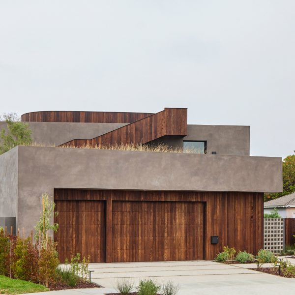 Concrete rectangular house with timber panelling on the ground floor and external staircase