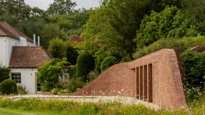 Brick pool house by Knox Bhavan buried under a grass mound in the garden of a Kent home