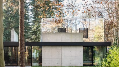 Two-storey house in a forest with mirror-clad upper level