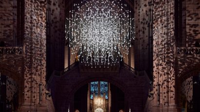 Spherical installation made up of suspended piece of coal illuminated inside a cathedral