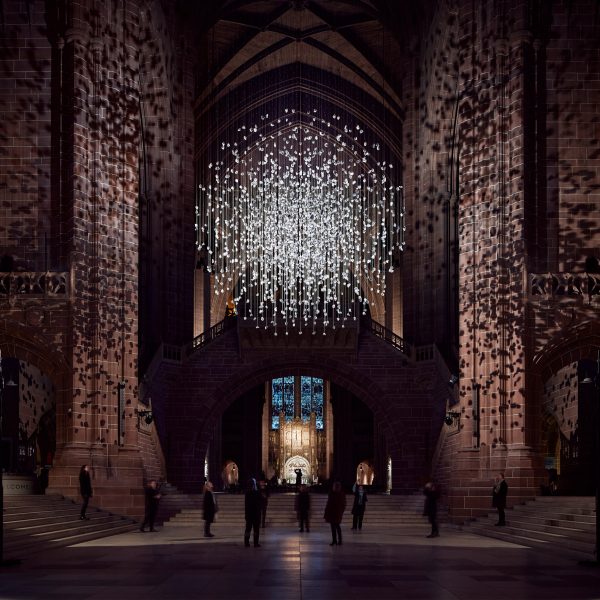 Spherical installation made up of suspended piece of coal illuminated inside a cathedral