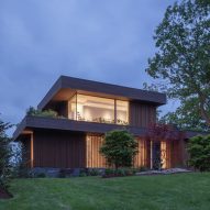 Exterior of a two-storey timber-clad lake house with front lawn by Worrell Yeung